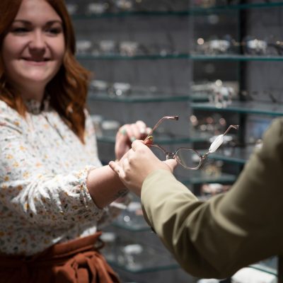 opticienne qui donne une paire de lunette à un client