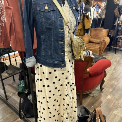 mannequin femme avec robe longue blanche à poids noirs, veste en jean et banane